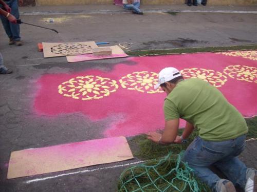 Man working on an alfombra further along the path where the procession will reach later in the day.