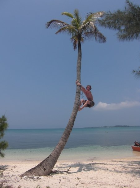 Eli Climbing Palm Tree on the Water Cay near Utila, Honduras.