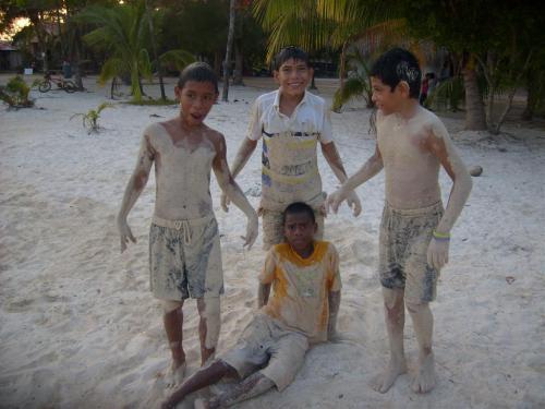 Local Utilian boys posing after playing in the sand at the public beach in Utila, Bay Islands, Honduras.